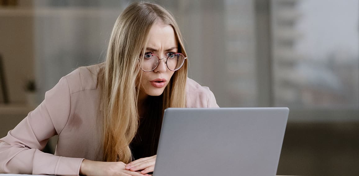 Shocked caucasian millennial business woman female student worker user receiving bad news message low grade test failed exams losing computer bet feeling shock lost fear horror looking at laptop