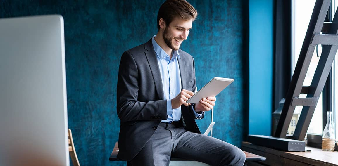 Handsome elegant businessman working on a tablet.