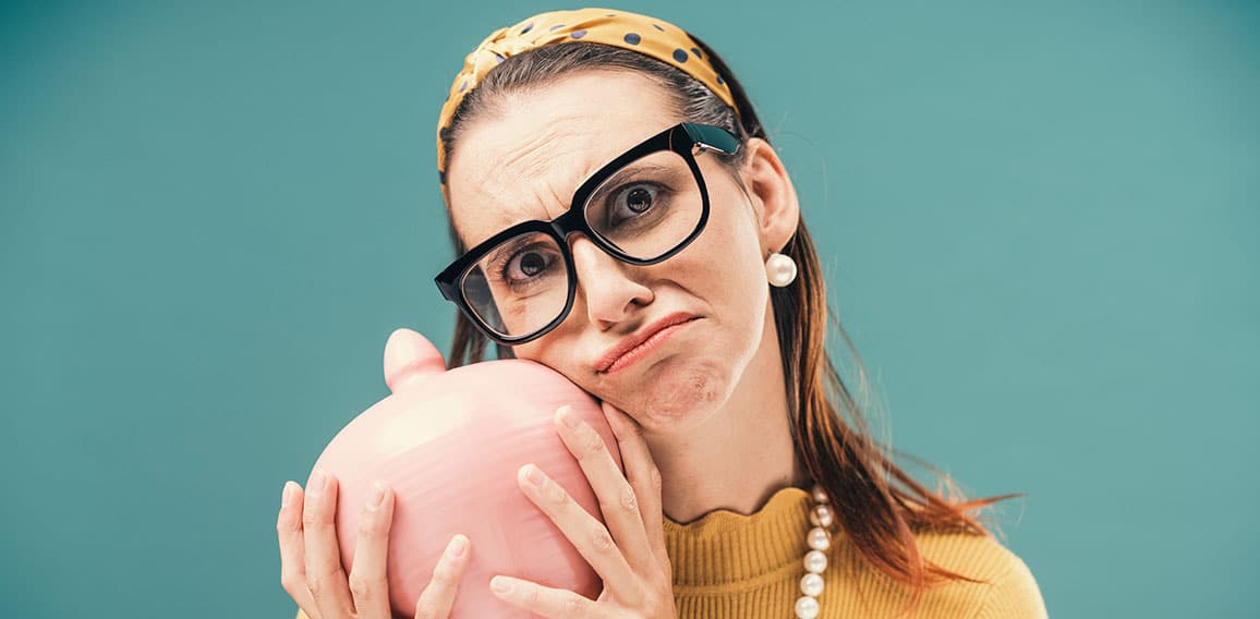 Disappointed woman holding a money box with her savings