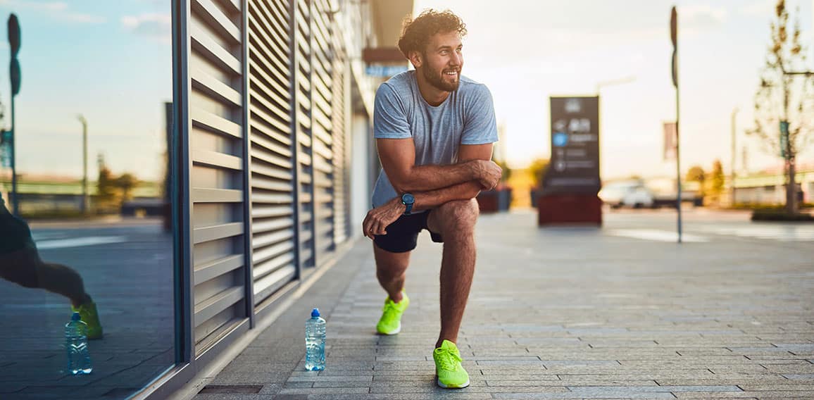 Young man exercising / stretching in urban area.