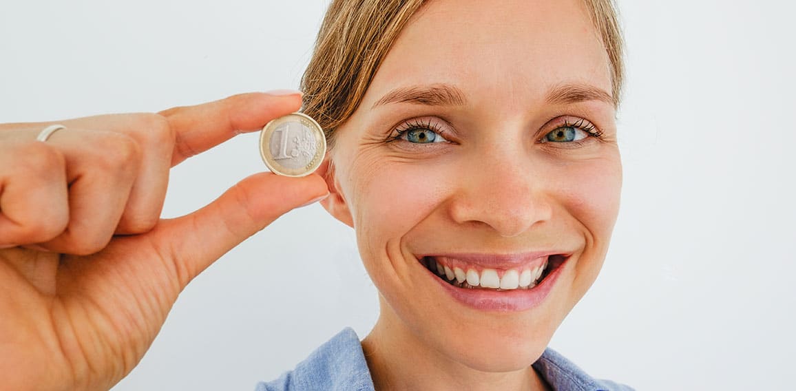 Closeup of Smiling Woman Holding One Euro Coin