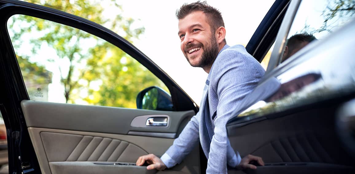 Smiling man exiting his vehicle