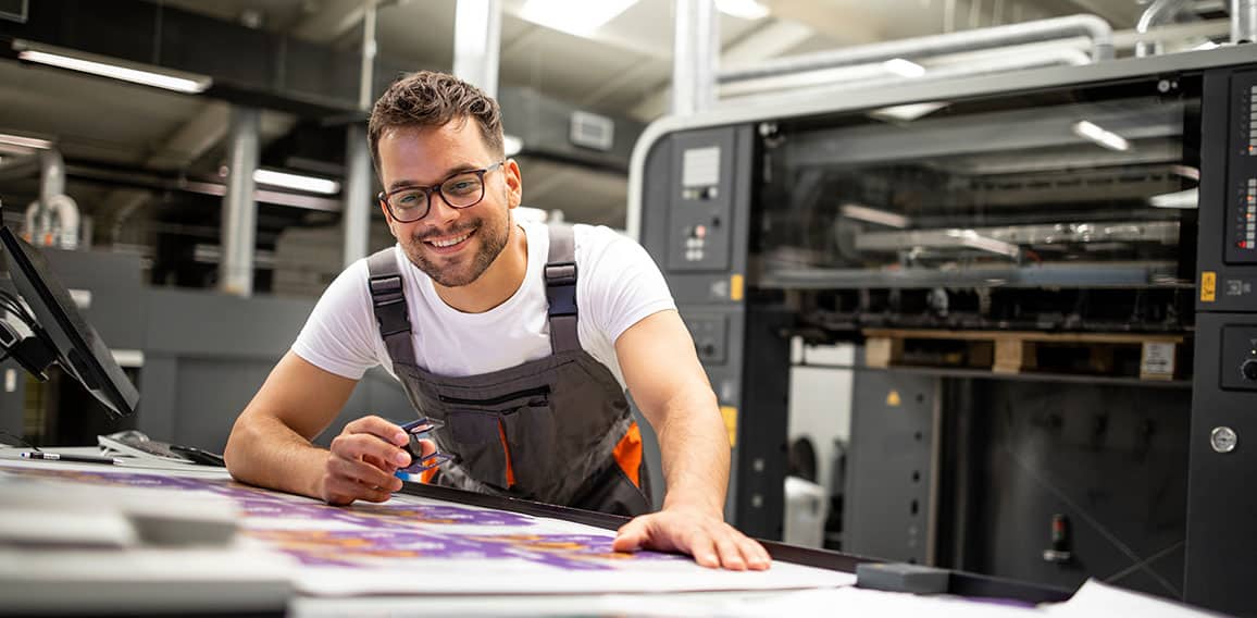 Print house worker controlling printing process quality and chec