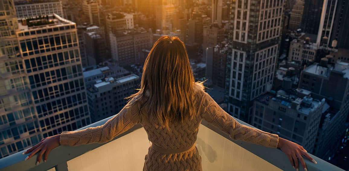 Rich woman enjoy the sunset standing on the balcony at luxury ap