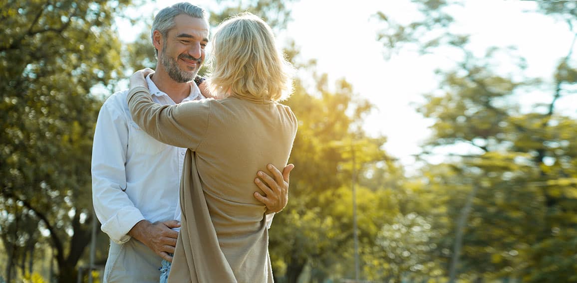 Senior Caucasian couple hugging in park. Family with a happy smi