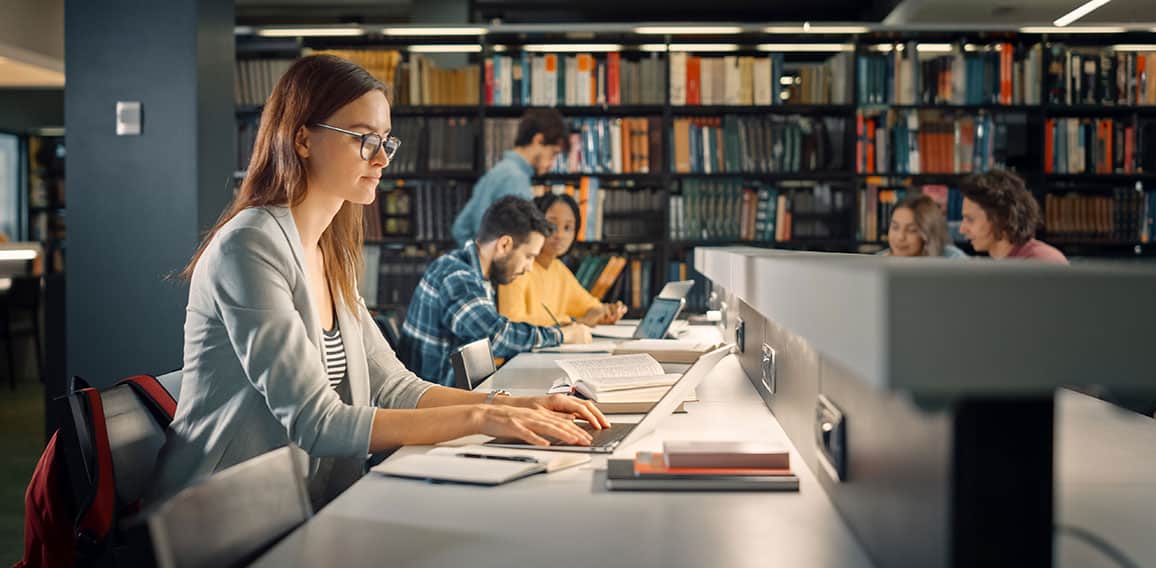 University Library: Talented Caucasian Girl Sitting at the Desk,