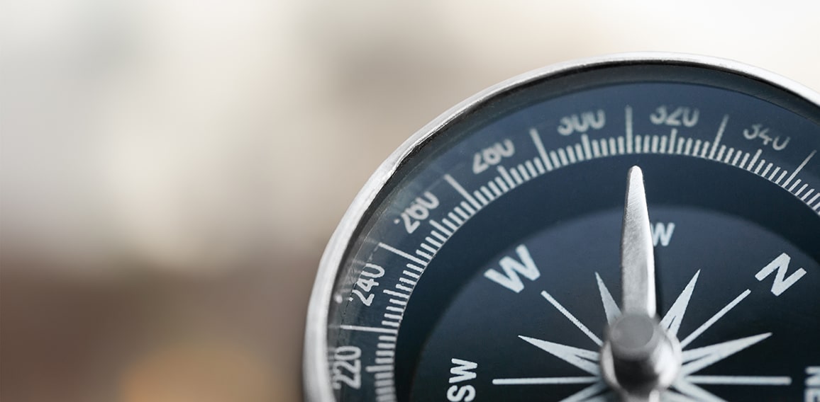 Close-up brass antique compass on marble table