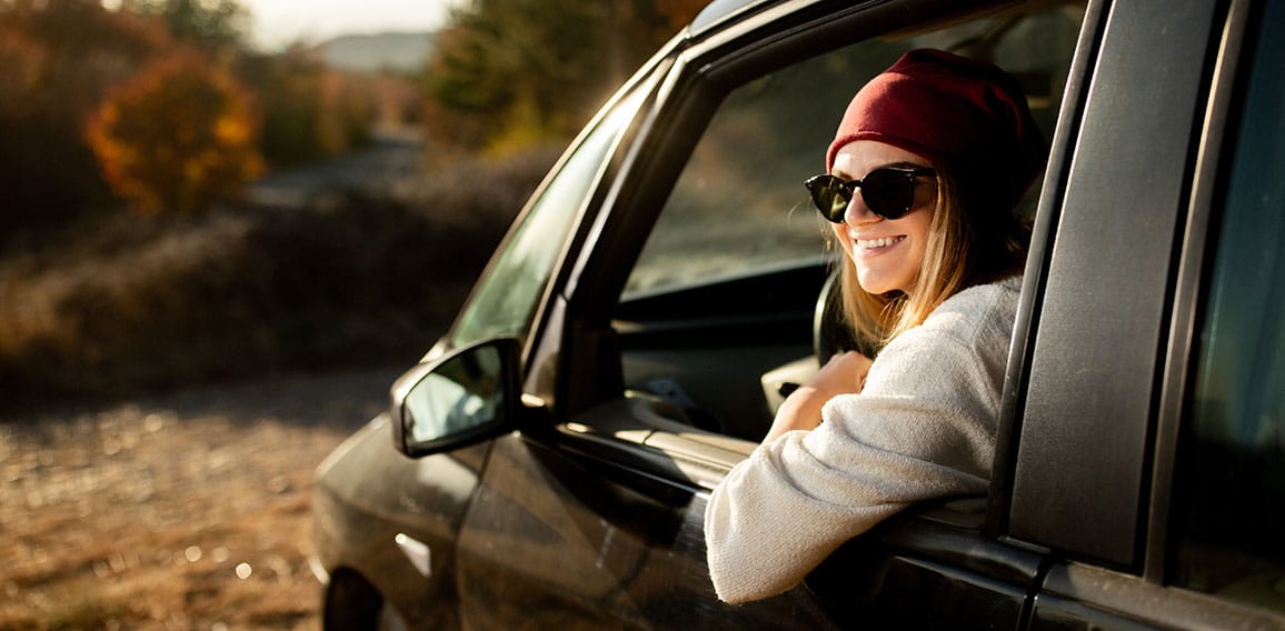 Woman driving in the car on the road trip