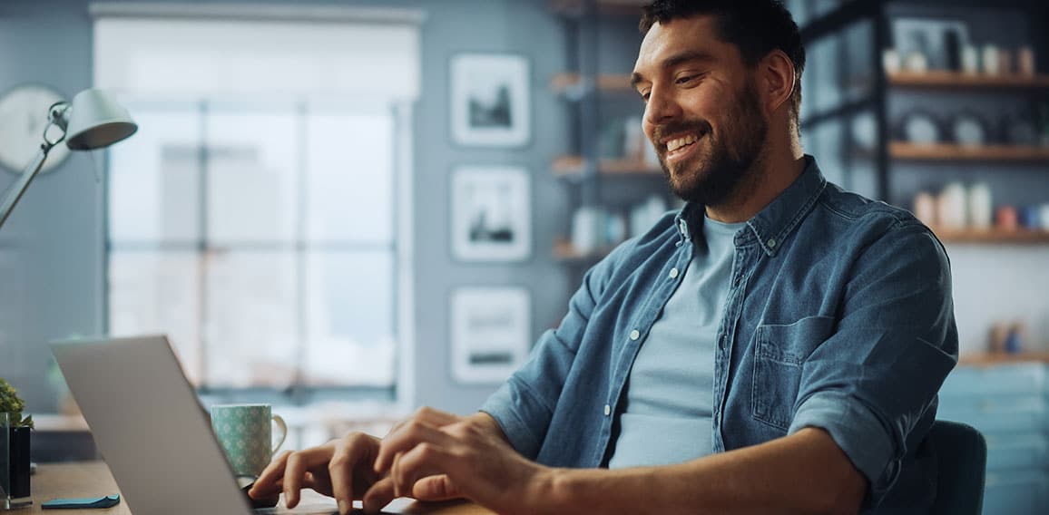 Handsome Caucasian Man Working on Laptop Computer while Sitting