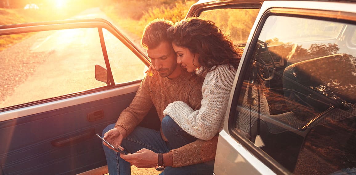 Beautiful couple on road trip, they are taking a break from driv