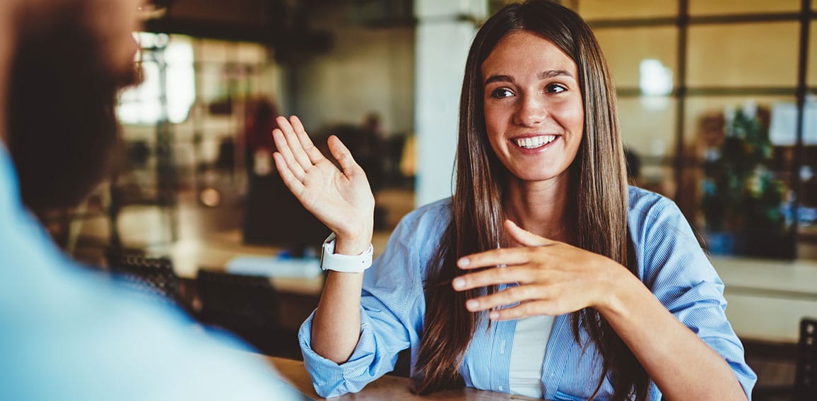 Happy successful hipster girl explaining information to male fri