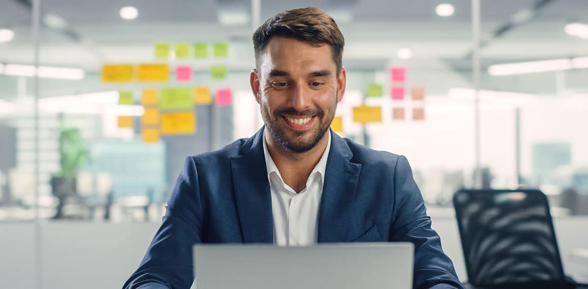 Busy Young Businessman Using Laptop Computer in Modern Office. M