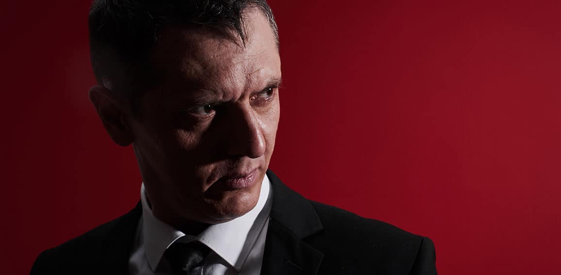 The evil boss. Portrait of an angry man in a business suit with red eyes with rage. Aggressive person