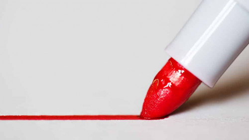 Red marker draws a line close up photo