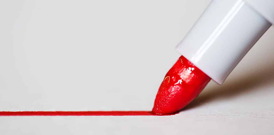 Red marker draws a line close up photo