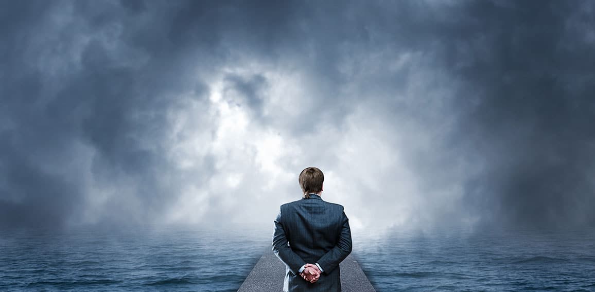 Man standing on pier looks at the sea