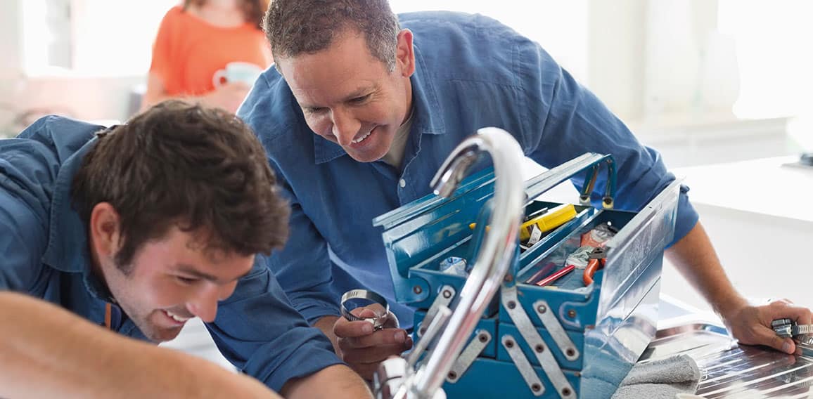 Plumbers working on kitchen sink