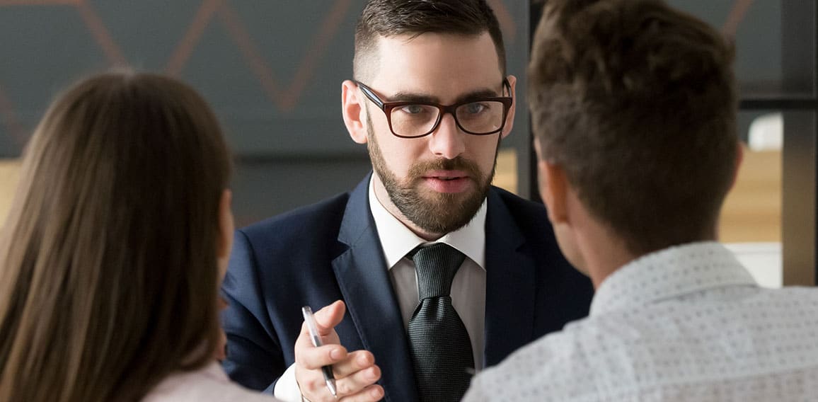 Rear view couple meets with realtor or real estate agent