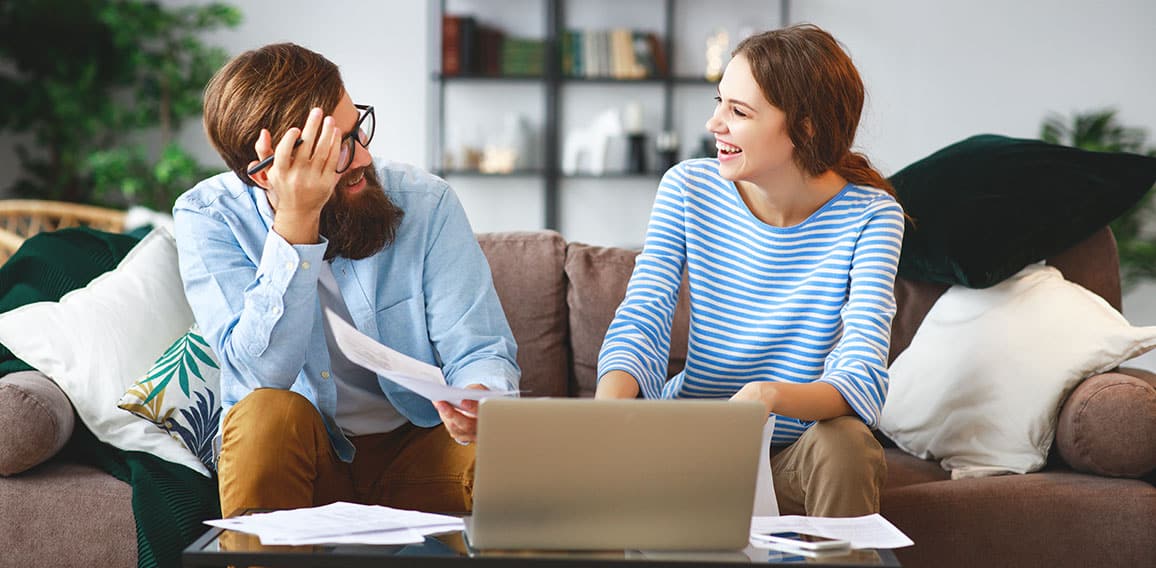 married couple with bills receipts documents and laptop at home