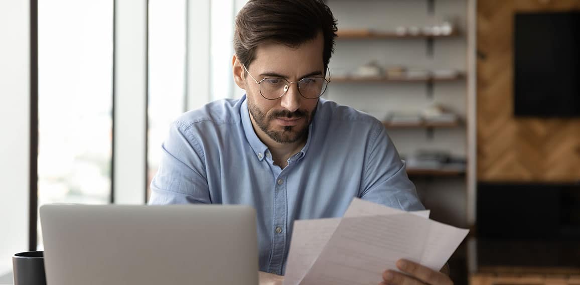 Focused businessman reviewing paper reports, received letter