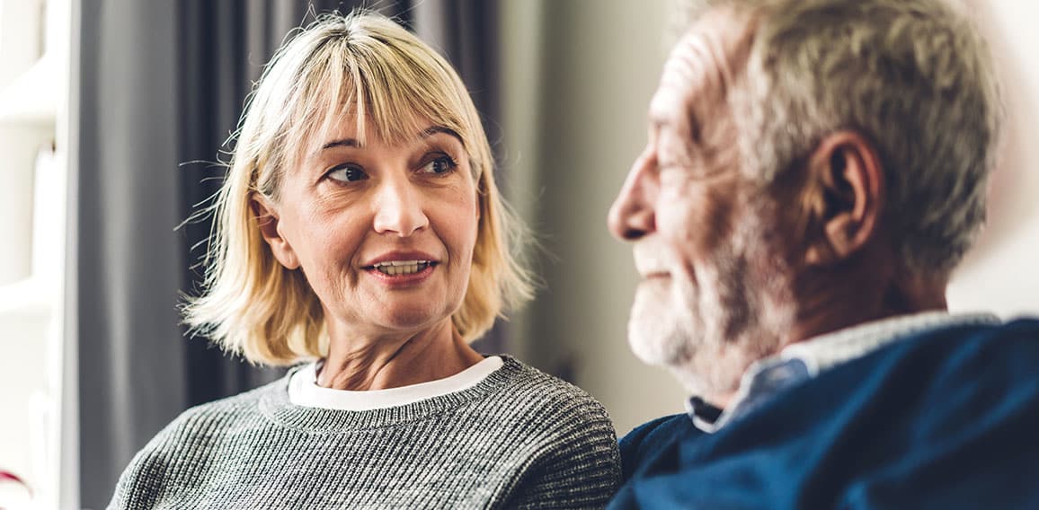 Senior couple relaxing and talking together sitting on sofa in l