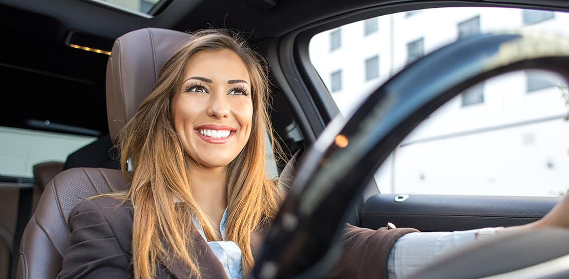 Beautiful businesswoman smiling in a car