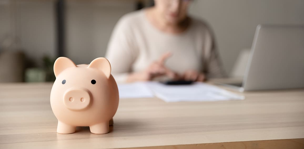 Toy pink piggy bank on work table of senior tenant