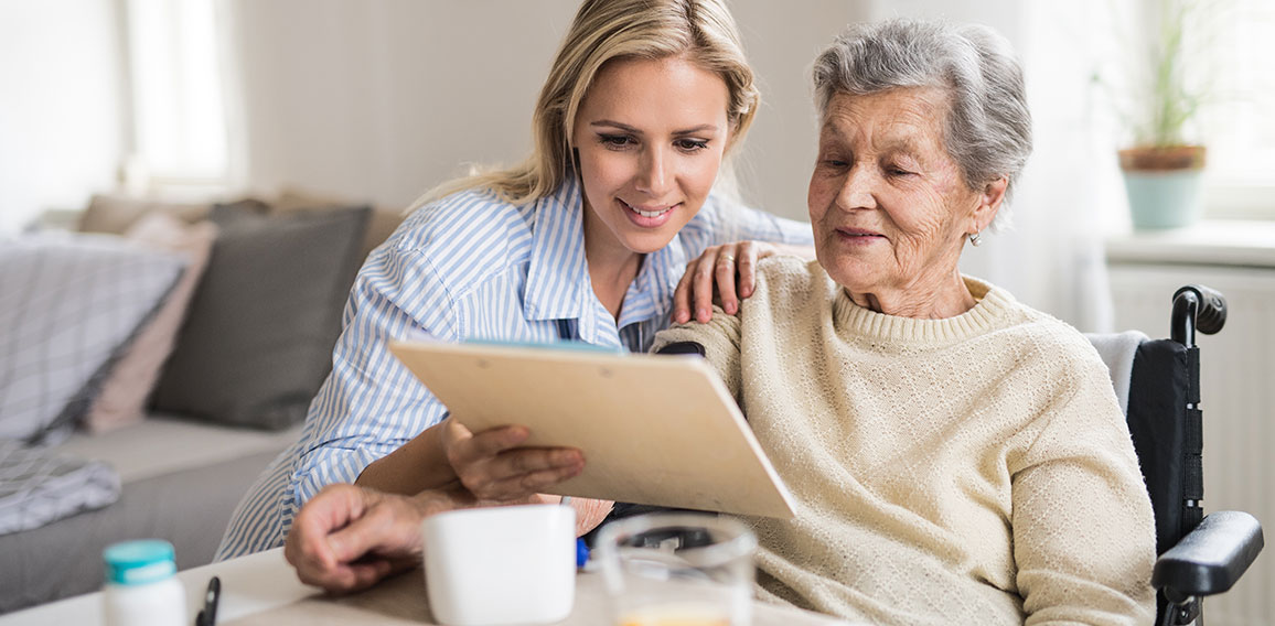 A health visitor measuring a blood pressure of a senior woman at home.