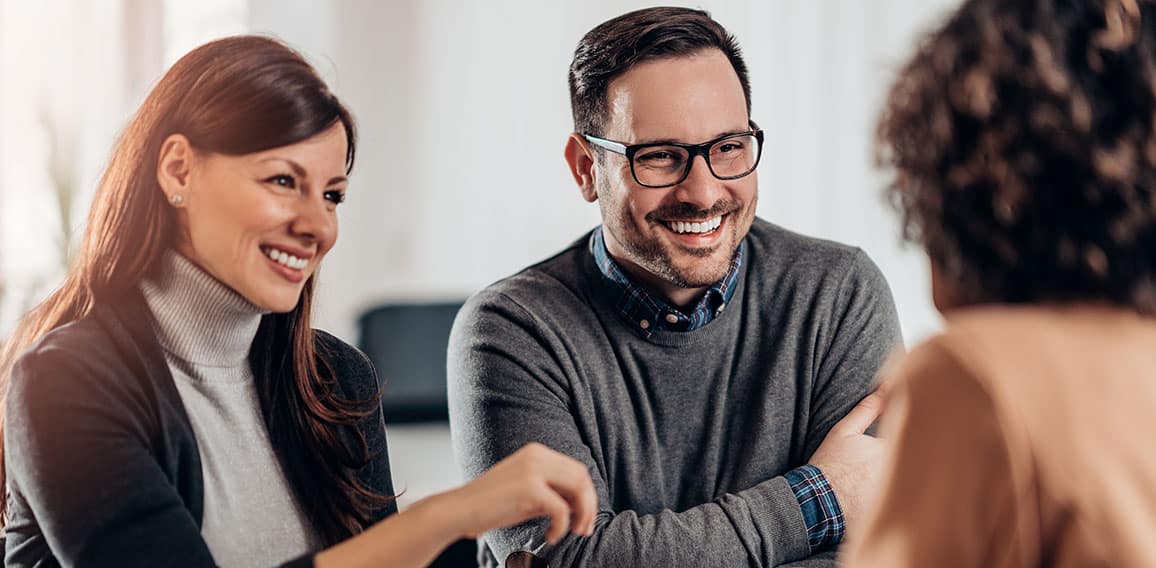 Happy couple talking with sales manager