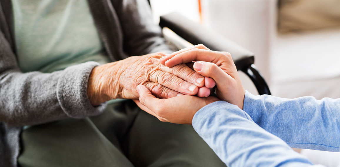 Unrecognizable health visitor and a senior woman during home vis