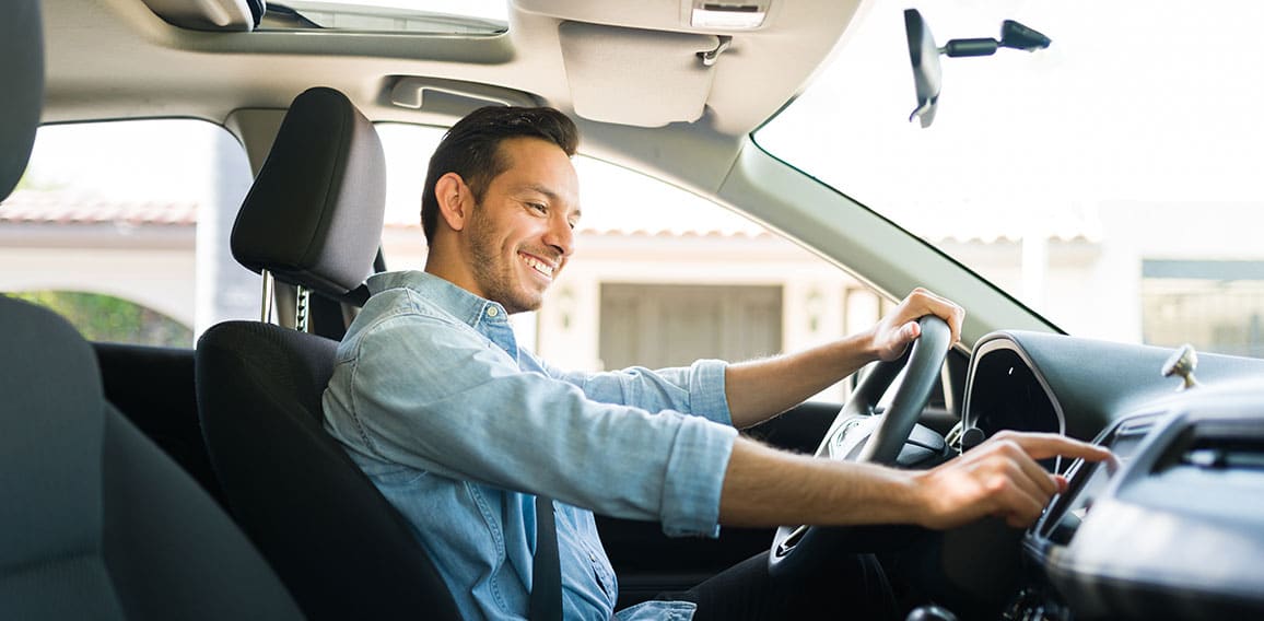 Attractive male driver using the GPS navigation map on the car