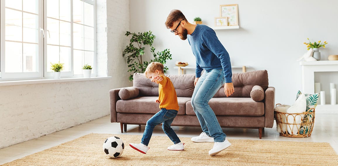 Father and son playing football at home