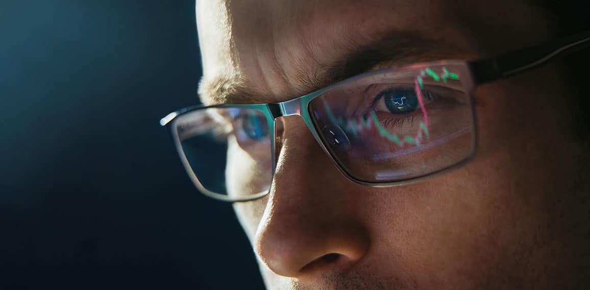 Portrait of trader wearing eyeglasses with reflection cryptocurrency chart