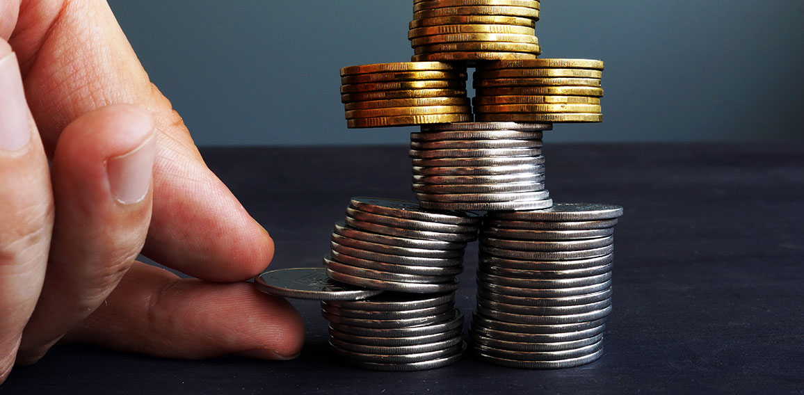 Financial Stability concept. Man holding coin in the coins stack.