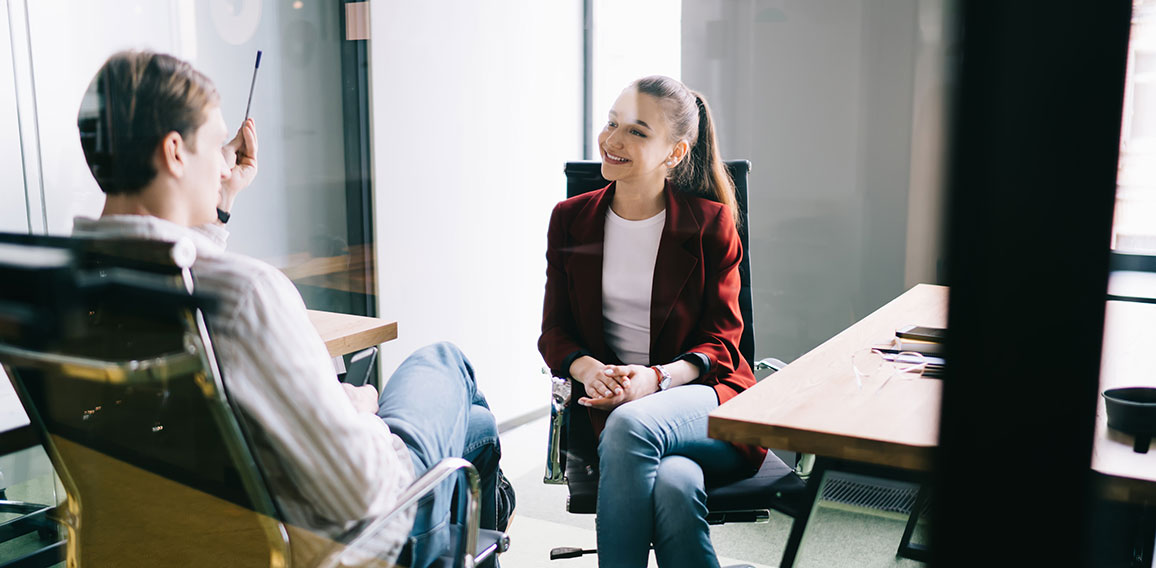 Cheerful office workers talking behind glass door