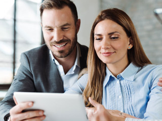 Happy couple using digital tablet on a meeting with insurance ag