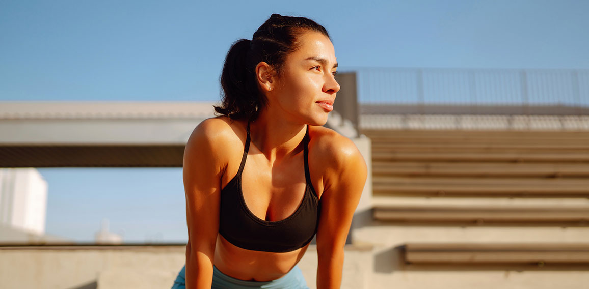 Young fitness woman exercising and stretching outdoors in the mo