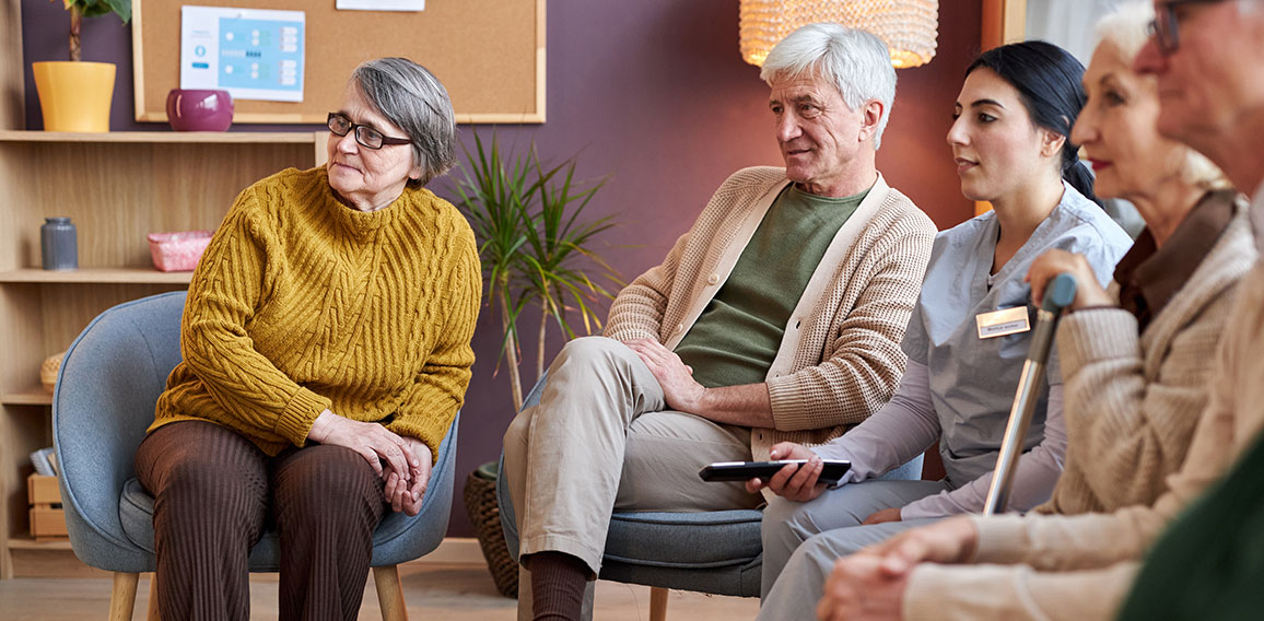 Elderly people watching TV in retirement home together