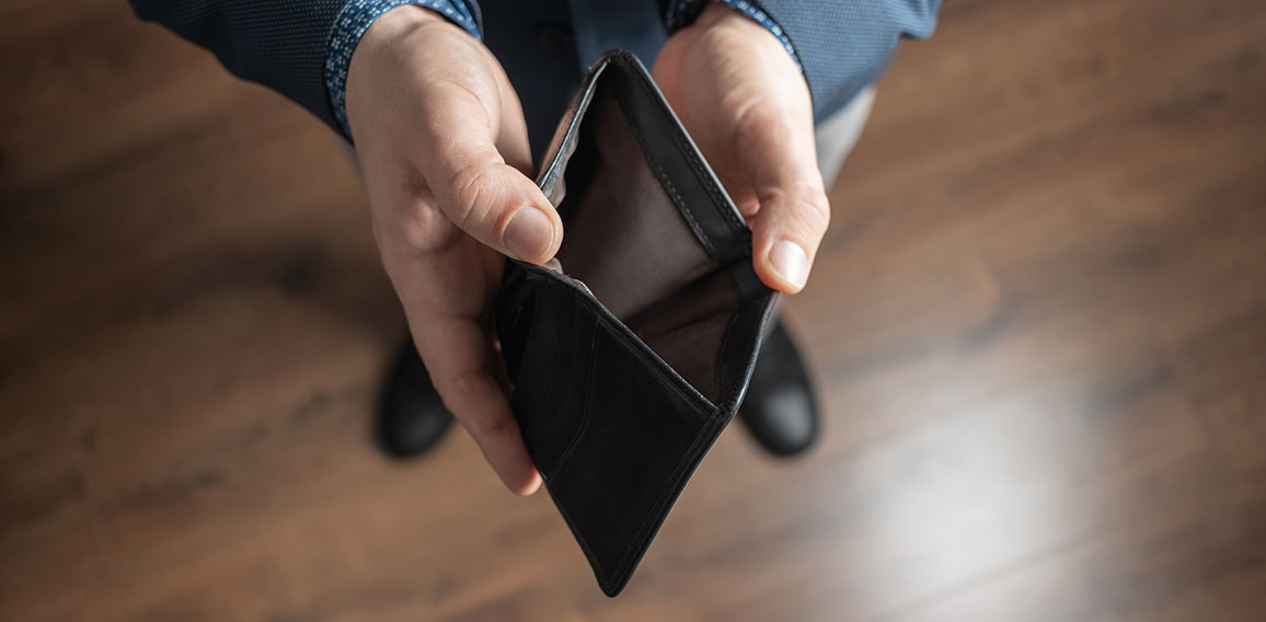 Well dressed man holding empty leather wallet. Financial crisis and bankruptcy concept