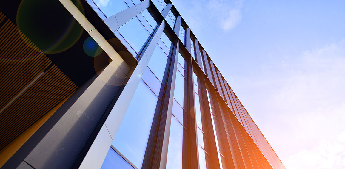 Glass modern building with blue sky background. Low angle view a