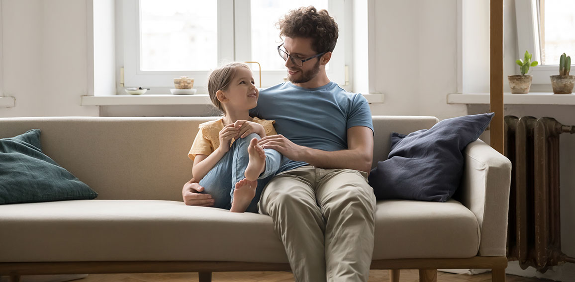 Happy loving dad hugging cute little daughter girl with tenderness