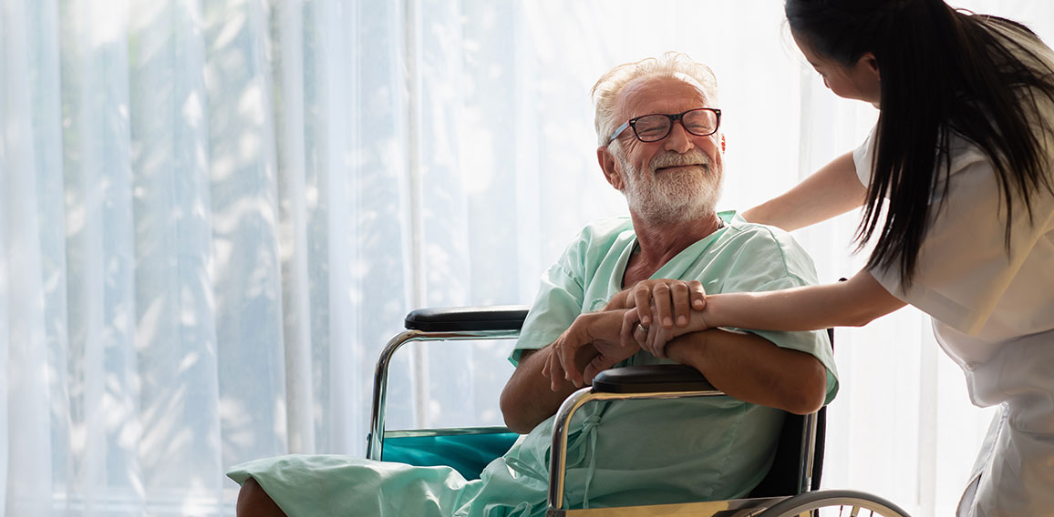 Eldery in wheelchair with nurse. An old man in a hospital, a nur