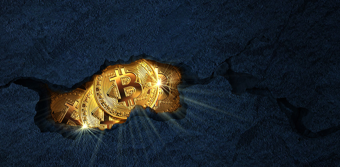 Golden bitcoins inside a rock cracked open