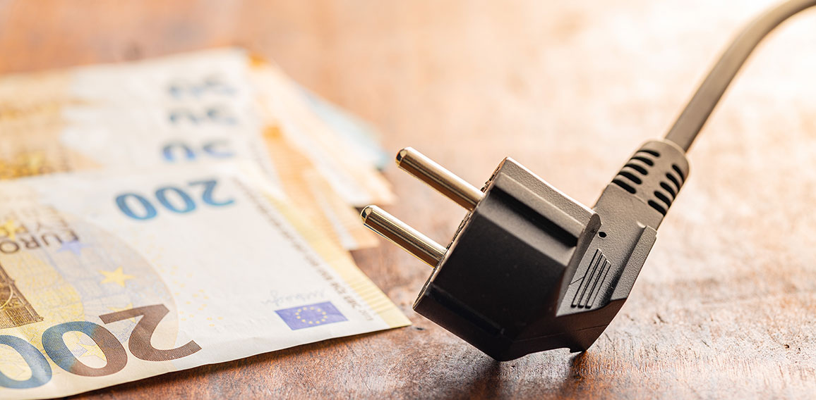 Electric plug and euro money on wooden table. Concept of increasing electric prices.