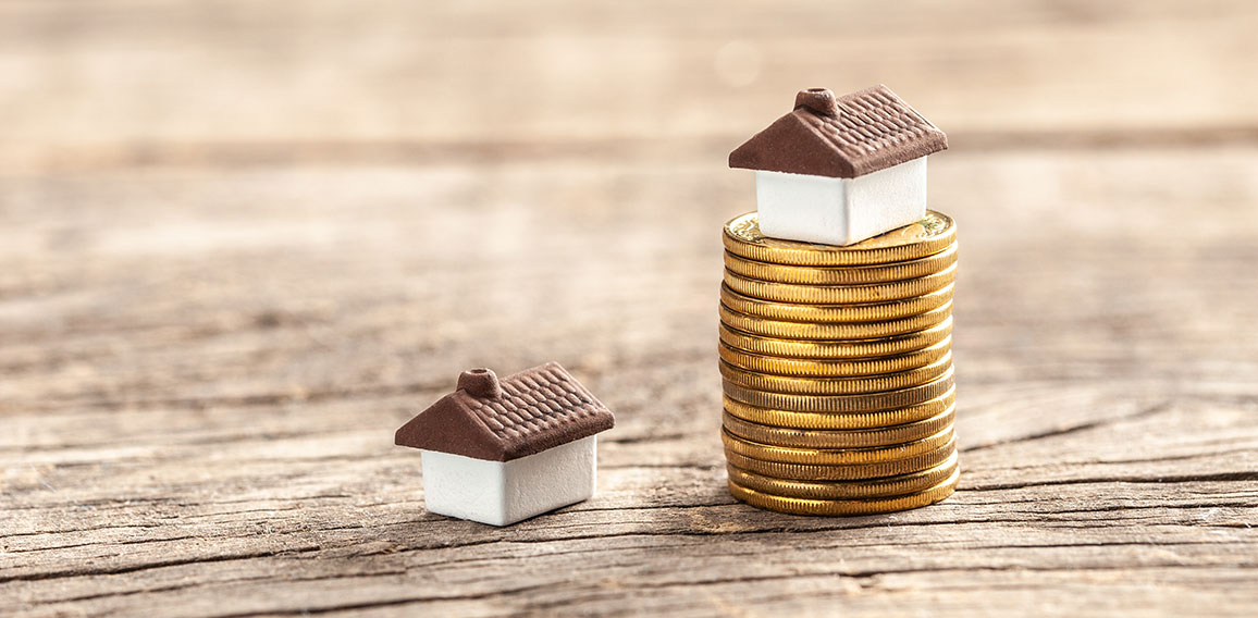 House and a stack of coins. The market price of the house. Real