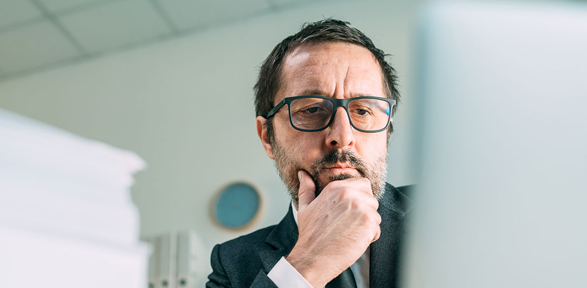 Panoramic portrait of worried businessman looking at laptop in b