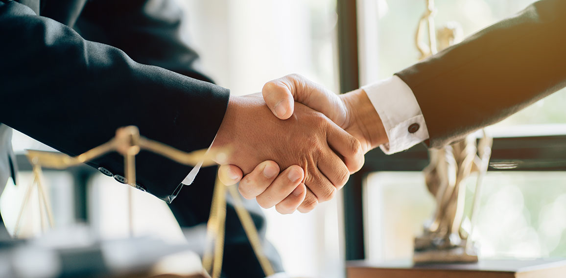 Businessman shaking hands to seal a deal with his partner lawyer