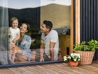 Young family with small daughter indoors, weekend away in container house in countryside.