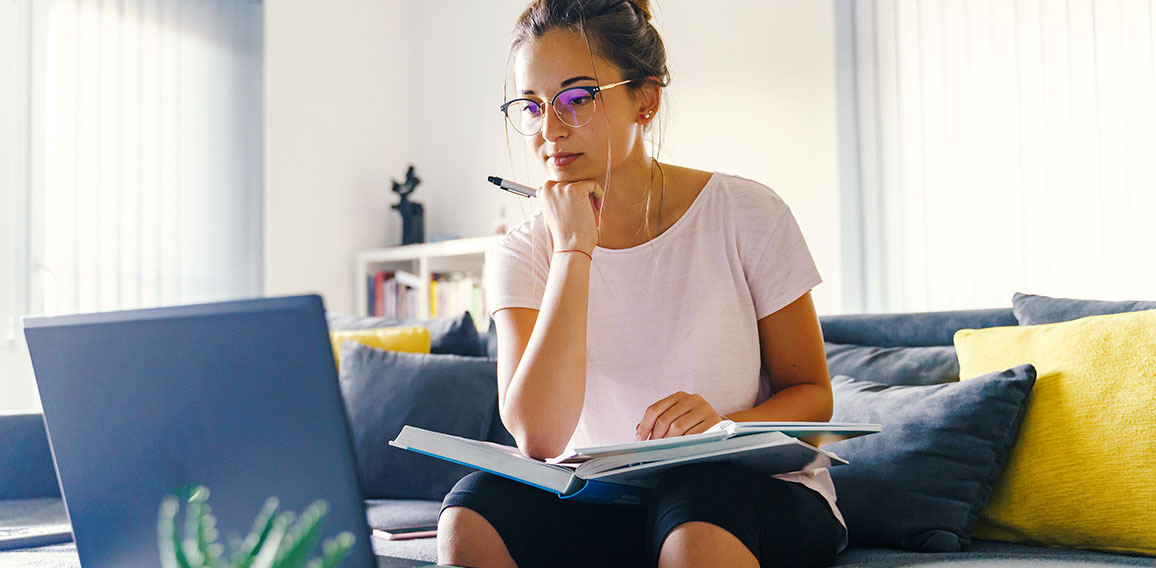 Front view on young caucasian woman study in front of the laptop