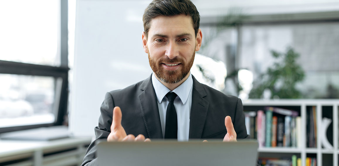 Concentrated caucasian businessman, information security engineer, insurance manager, sit in modern office, having video meeting with colleague using laptop, explaining working strategy,gestures hands